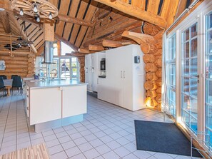 Eine moderne Küche mit einer zentralen Kochinsel, weißen Schränken und einer Wand als Steinakzent.