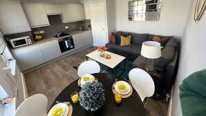 A modern apartment with a kitchen, dining area, and living room. - Stanhope Road Apartments (London)