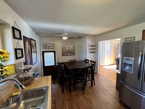 A kitchen with a dining table, chairs, a refrigerator, and a sink. - BEAVERCREEK-3bedroom/2bath cozy house near Summit Park (Sharonville)