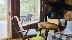 A cozy room with a large window, a round wooden table, and a chair. - 6 Person Holiday Home in Halden-by Traum (Halden)