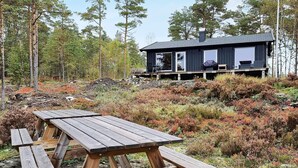 A cabin with a deck and a picnic table in a forested area. - 6 Person Holiday Home in Halden-by Traum (Halden)