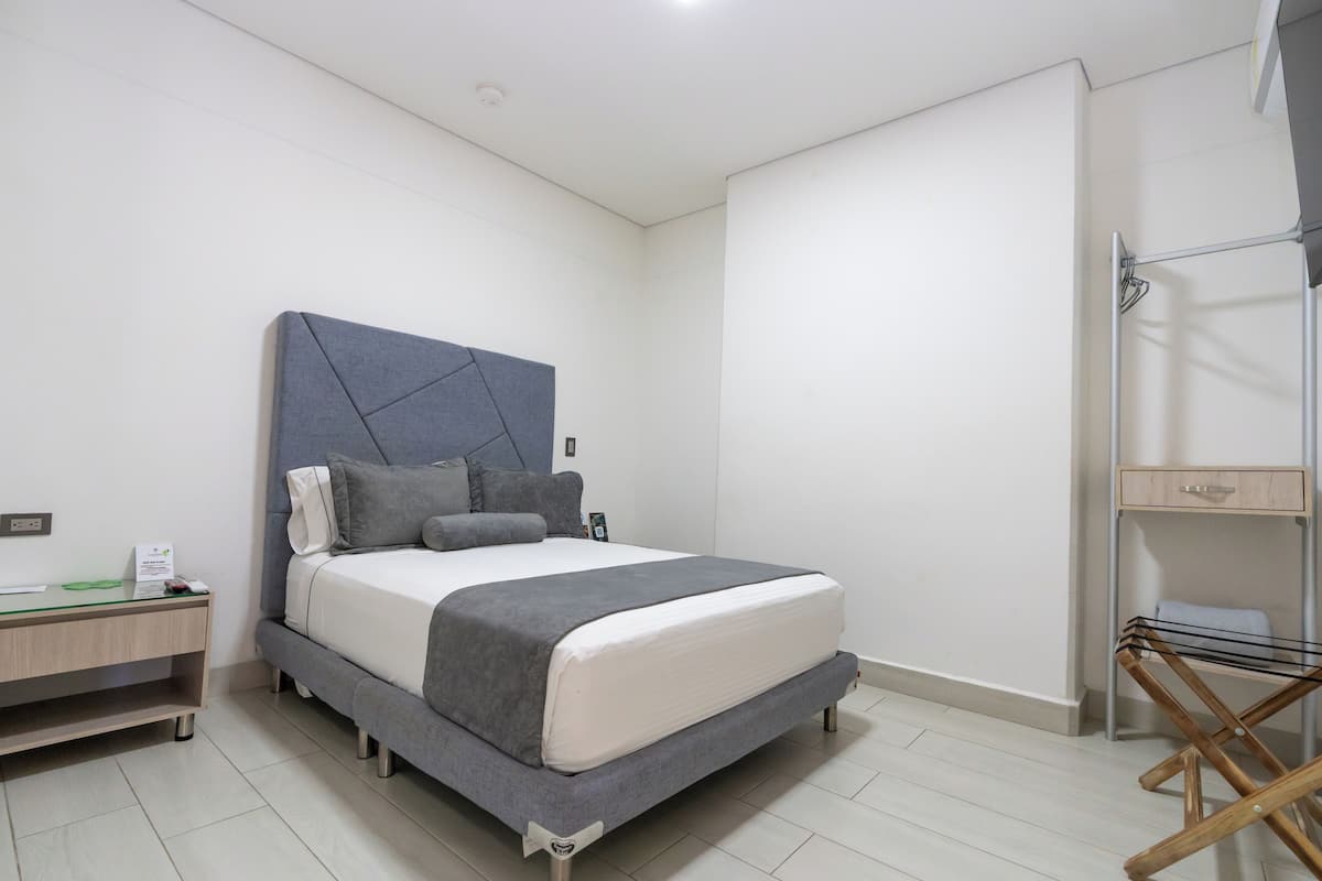 A modern bedroom with a bed, bedside tables, and a built-in wardrobe.