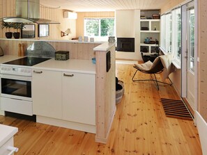 A modern kitchen with wooden cabinets, a built-in stove, and a large window. - 6 Person Holiday Home in Hadsund (Hadsund)