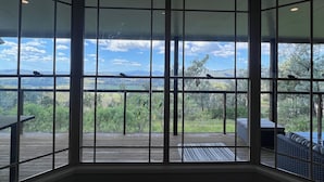 A room with large windows offering a view of a deck and landscape. - Scenic View Esk Escape (Esk)