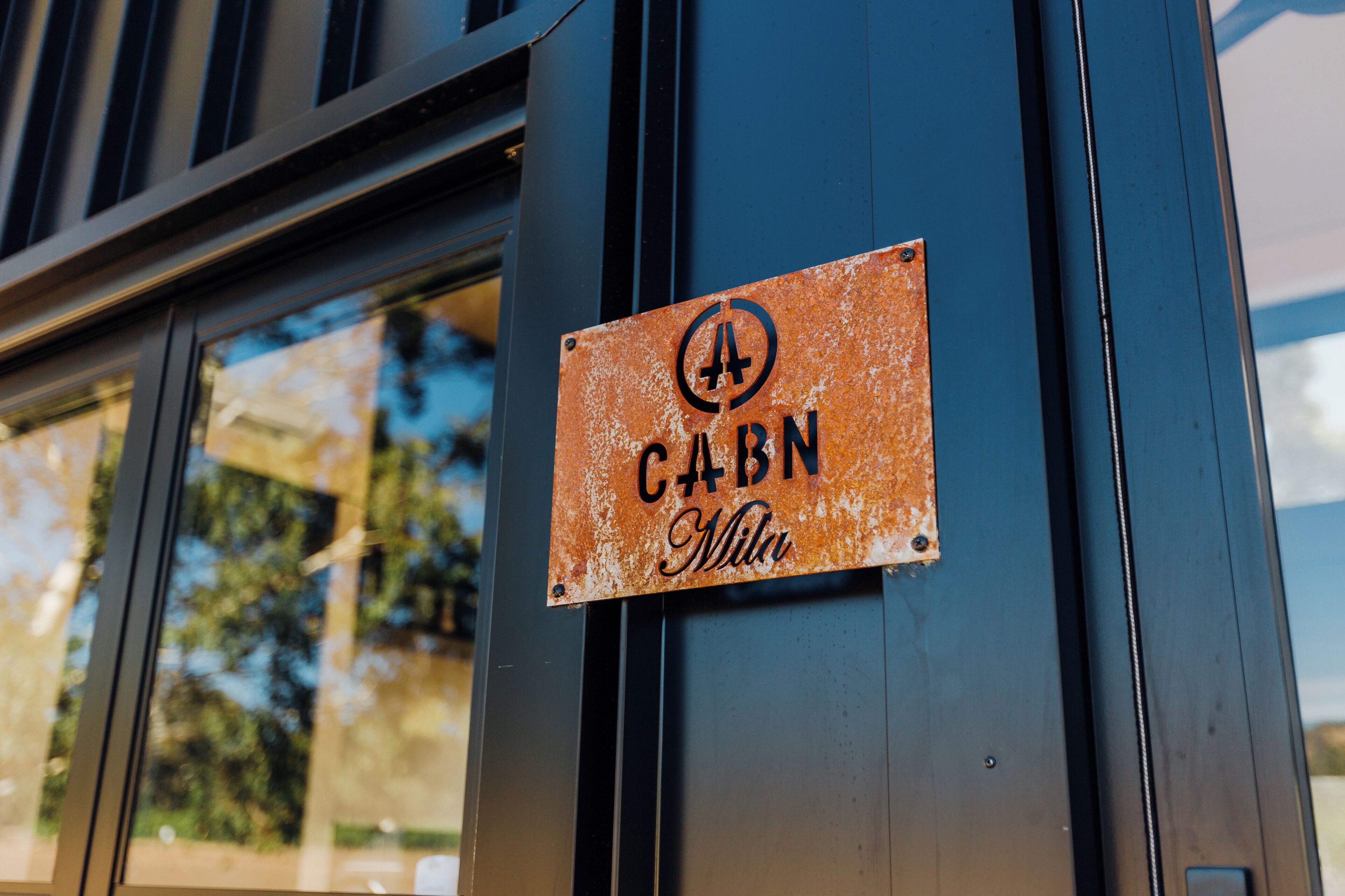 Ein Schild an einem Gebäude mit dem Schriftzug 'CABN Milu'.