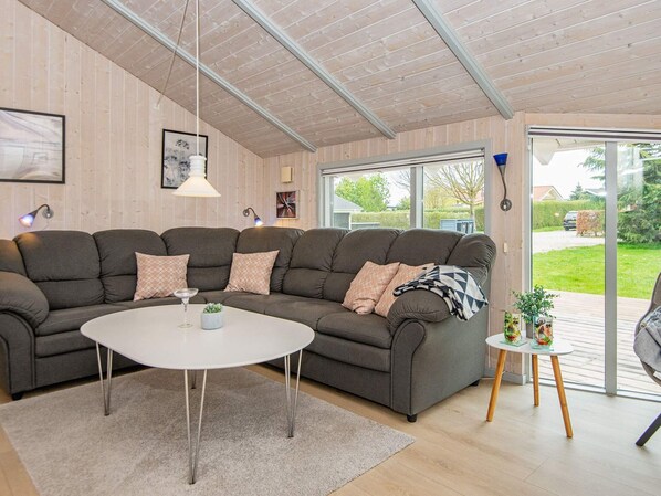 A modern living room with a sectional sofa, a round coffee table, and a small side table with decorative items.