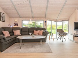A modern living room with a sectional sofa, a coffee table, and a TV stand.