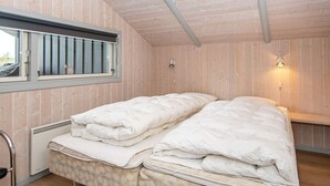 A room with two beds, a window with a view, and a wall-mounted light fixture. - 5 Star Holiday Home in Borkop (Borkop)