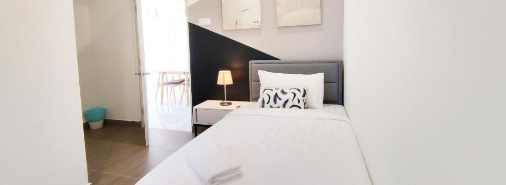 Ein Hotelzimmer mit Bett, Nachttisch, Lampe und Blick ins Freie.