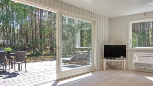A room with a large sliding glass door leading to a deck with outdoor furniture. - 7 Person Holiday Home in Nexo (Nexø)
