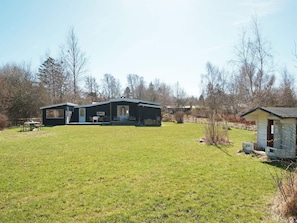 A two-story house with a large front lawn, a separate garage, and a small shed. - 4 Star Holiday Home in Vejby (Vejby)