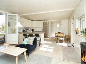 A modern kitchen with white cabinets, a central island, and bar stools. - 4 Star Holiday Home in Vejby (Vejby)