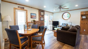 A cozy living room with a fireplace, a television, and a comfortable couch. - Walk to Downtown! 2-bedroom with mountain views (Ouray)