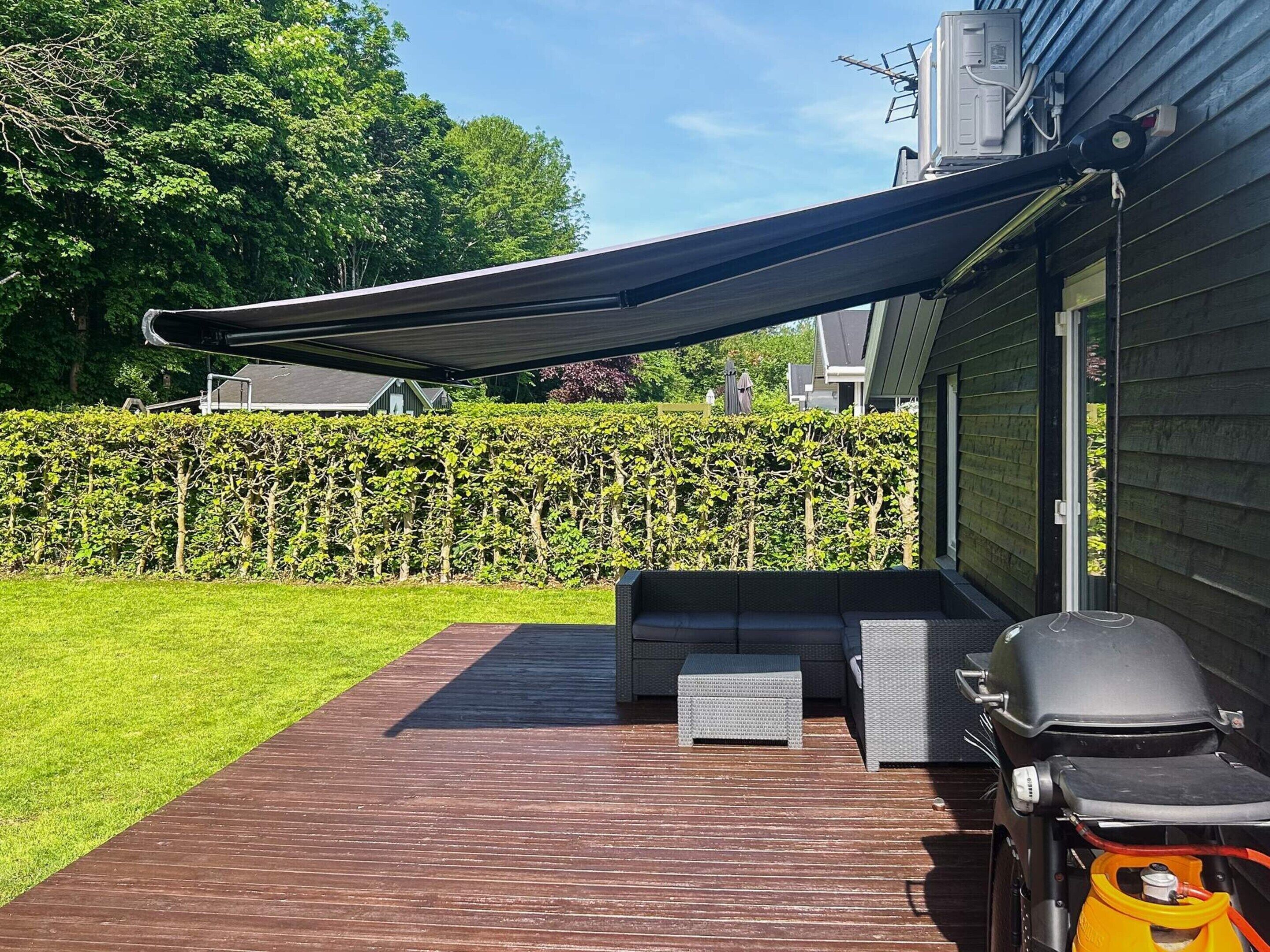 A patio with a grill, outdoor seating, and a covered area.