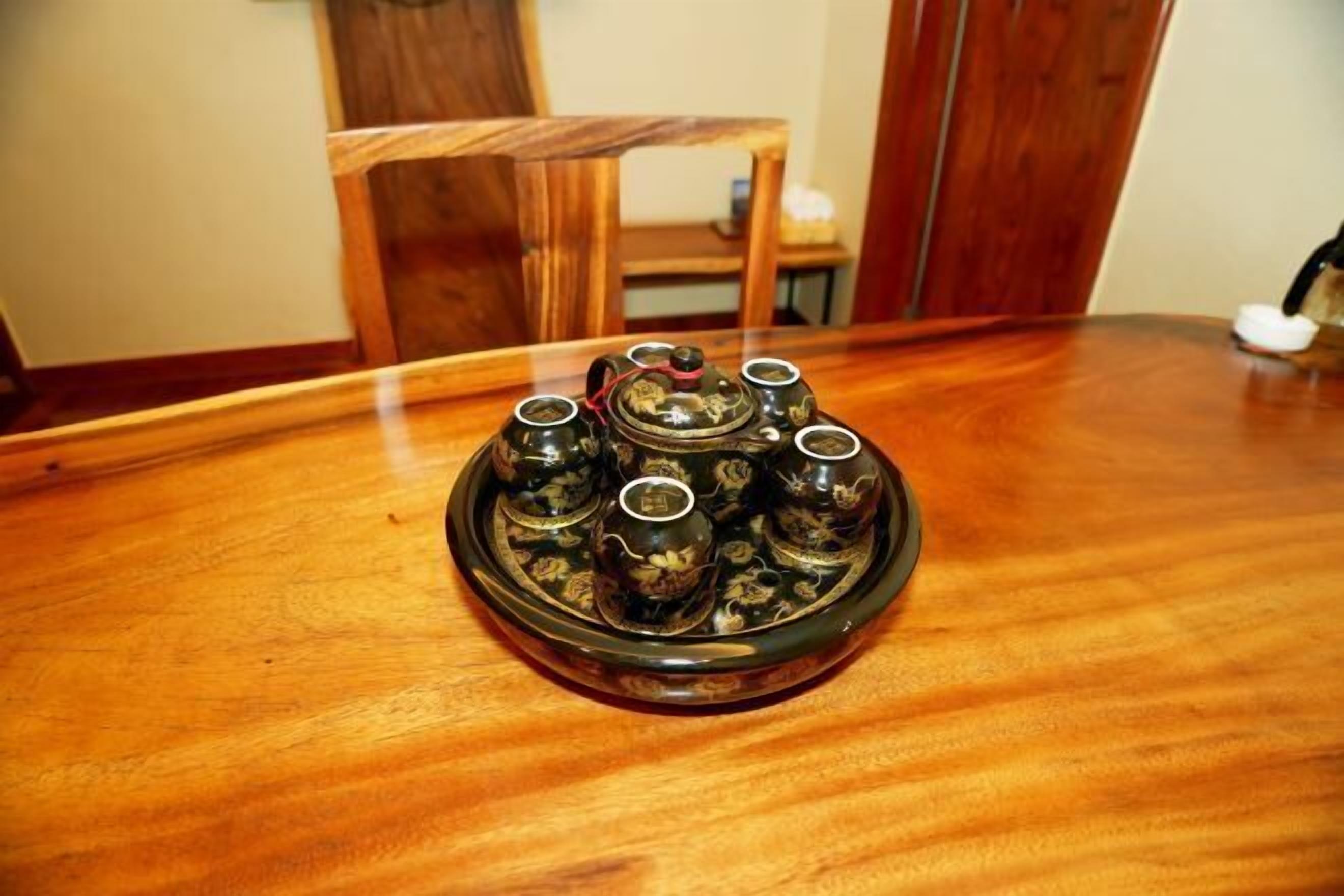 Uma mesa de madeira com um objeto de vidro decorativo com várias garrafinhas.