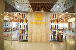 Un espace d’accueil circulaire, doté d’un logo central, de cloisons en verre et d’un design de plafond moderne.