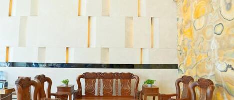 A room with a wooden dining set, a patterned wall, and a stone accent wall.