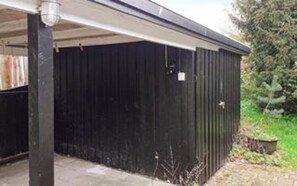A black metal shed with a door, a small window, and a metal roof.