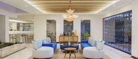 A spacious living area with two sofas, a coffee table, and a chandelier.