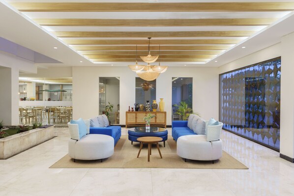 A spacious living area with two sofas, a coffee table, and a chandelier. - Swiss-Belcourt Lombok (Praya)