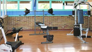 A gym with exercise equipment, a brick wall, and windows. - 7 Person Holiday Home in Nexo (Nexø)