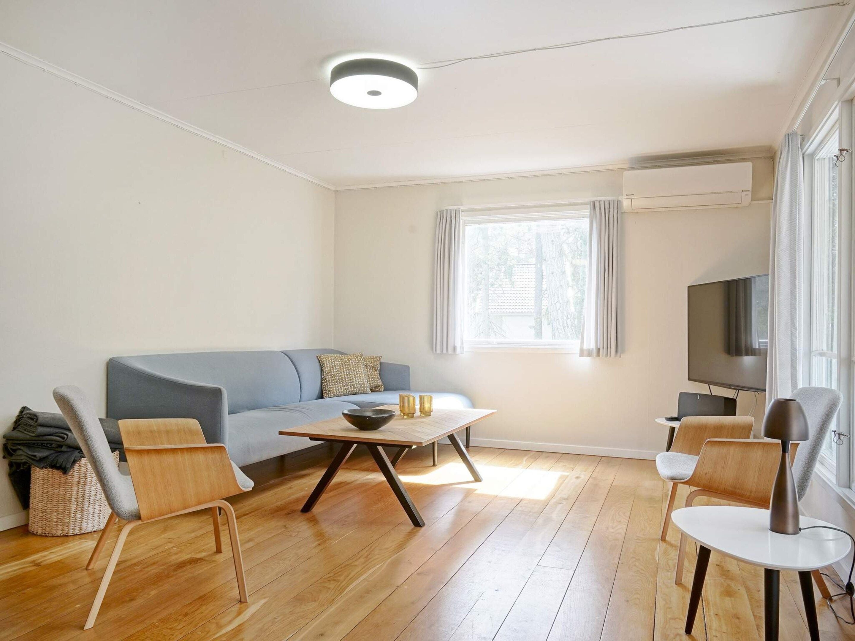 Uma sala de estar moderna com sofá, mesa de centro e cadeiras.