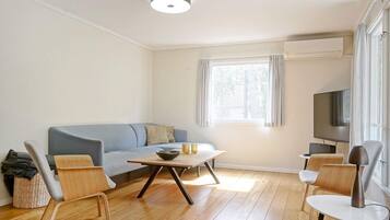 Una sala moderna con un sofá, una mesa de centro y sillas.