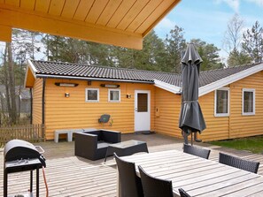 A wooden deck with outdoor furniture, a barbecue grill, and a covered patio area. - 7 Person Holiday Home in Nexo (Nexø)