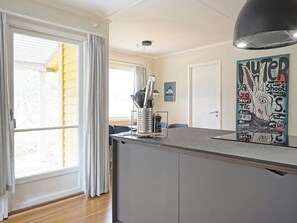 Una cocina con ventana, un cuadro y una lámpara en el techo.