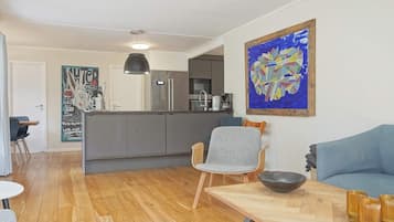 Un espacio de estar moderno con cocina, comedor y zona de asientos.