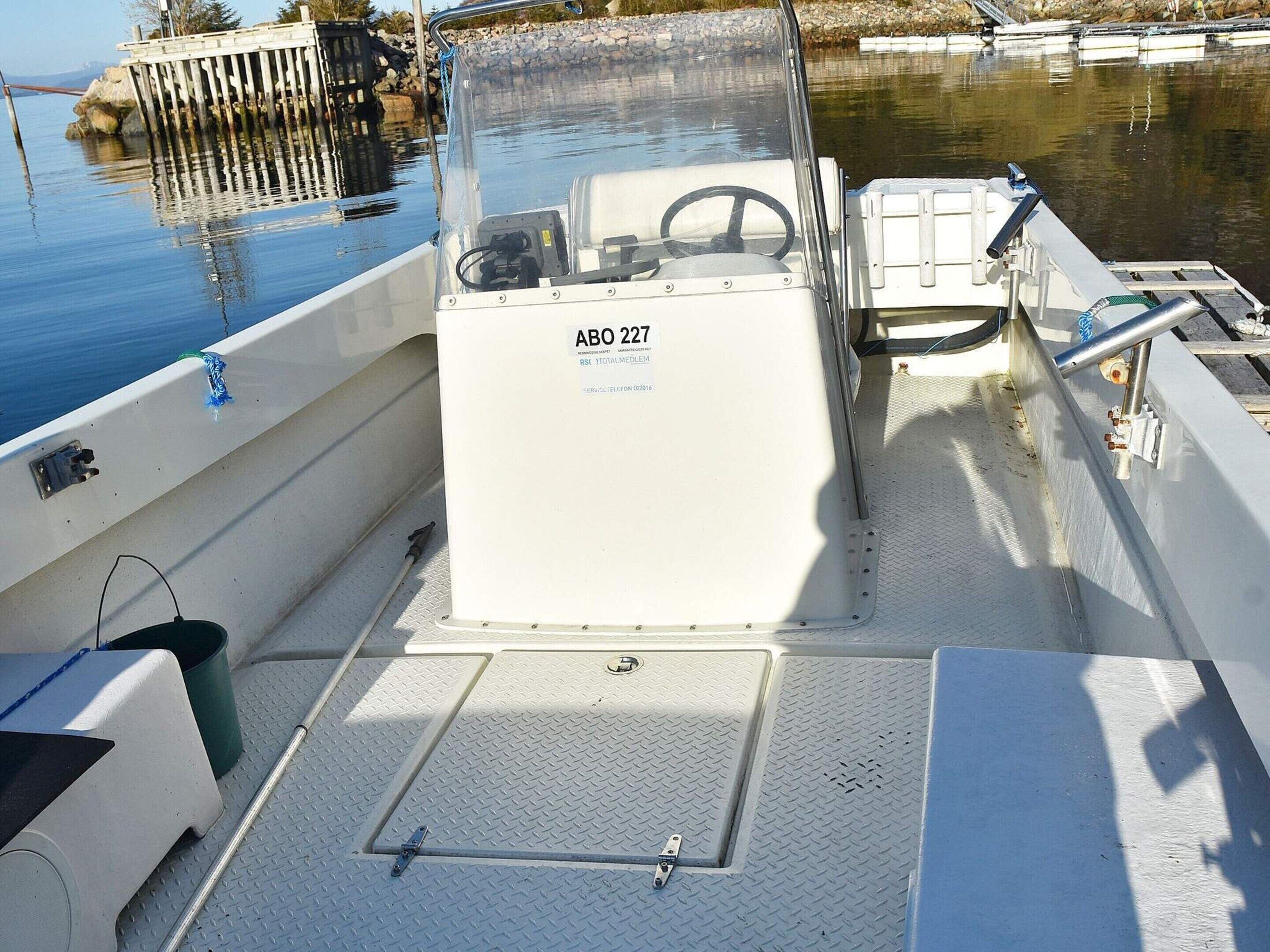 A boat's deck with a control panel labeled "ABO 227", a steering wheel, and a metal ladder.