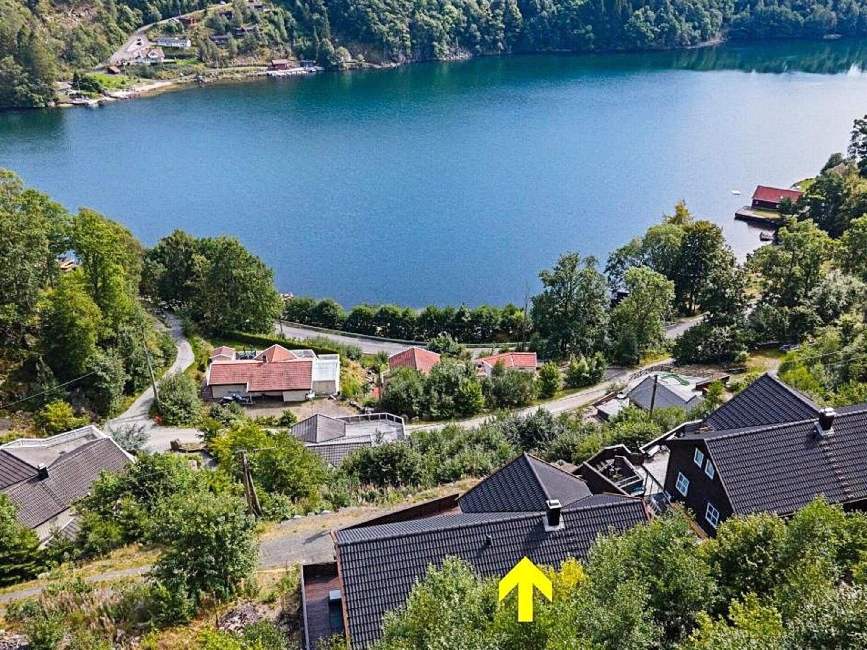 Een woongebied met huizen nabij een meer, omringd door groen.