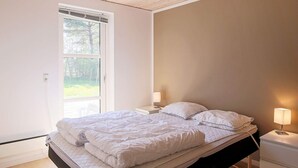 A bedroom with a bed, bedside lamps, a window, and a view of the outdoors. - 10 Person Holiday Home in Vaeggerlose (Vaeggerlose)