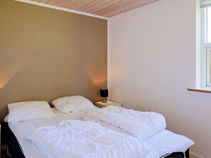 A single bed with white bedding in a room with a wooden ceiling and a window on the right. - 10 Person Holiday Home in Vaeggerlose (Vaeggerlose)