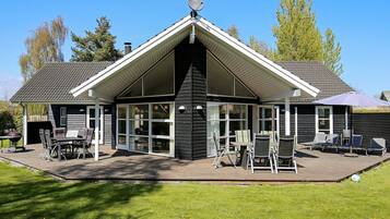 A house with a large deck, a covered patio, and a satellite dish.