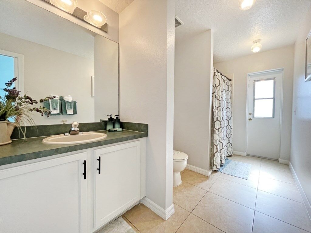 A bathroom with a sink, mirror, and toilet.