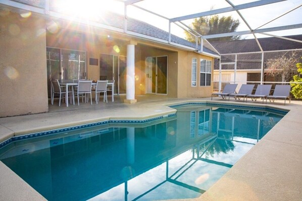A swimming pool with a covered patio area, outdoor seating, and a clear view of the pool. - Lakeside Sunset 3 Bedroom by RedAwning (Davenport)