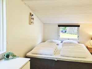 A room with a bed, a window, and a wall-mounted electrical panel.