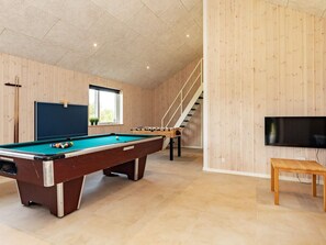 A pool table with a foosball table and a television in a room with wooden walls and a staircase. - 20 Person Holiday Home in Hojslev (Hojslev)