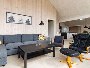 A modern living room with a sofa, coffee table, and a black leather chair. - 20 Person Holiday Home in Hojslev (Hojslev)
