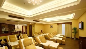 Une chambre d’hôtel équipée de plusieurs fauteuils inclinables, d’une télévision et d’un coin bar.