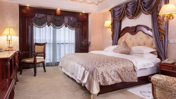 Une chambre d’hôtel avec un grand lit, un bureau et une chaise.