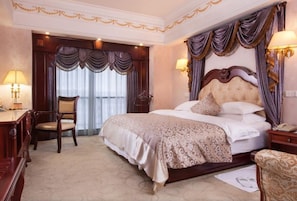 Una habitación de hotel con una cama grande, un escritorio y una silla.