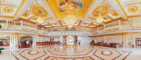 A grand lobby with a central fountain, multiple seating areas, and a high ceiling with intricate designs.
