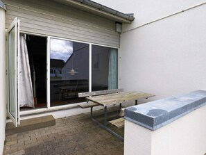 A patio area with a wooden bench, a table, and a sliding glass door leading to an interior space. - 6 Person Holiday Home in Brovst (Brovst)
