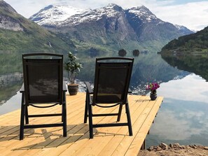 Two chairs facing a calm lake with mountains in the background. - 3 Person Holiday Home in Stryn (Stryn)