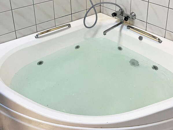 A bathtub with a faucet and a handheld showerhead. - 10 Person Holiday Home in Dannemare (Dannemare)