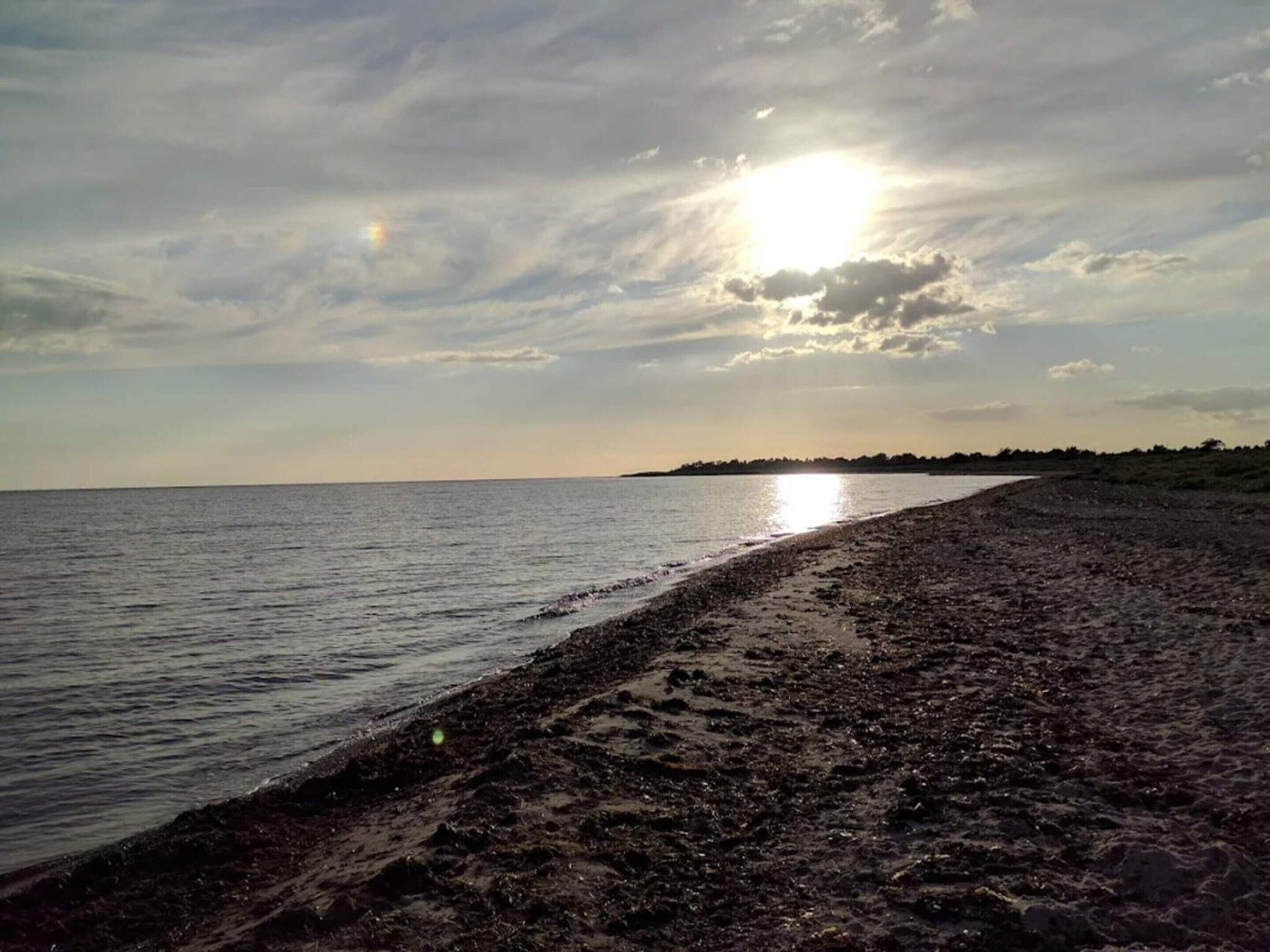 A beach with a wide sandy shore and calm water.