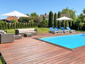 A wooden deck with a pool, lounge chairs, and a sofa. - 6 Person Holiday Home in Hornbaek (Hornbaek)