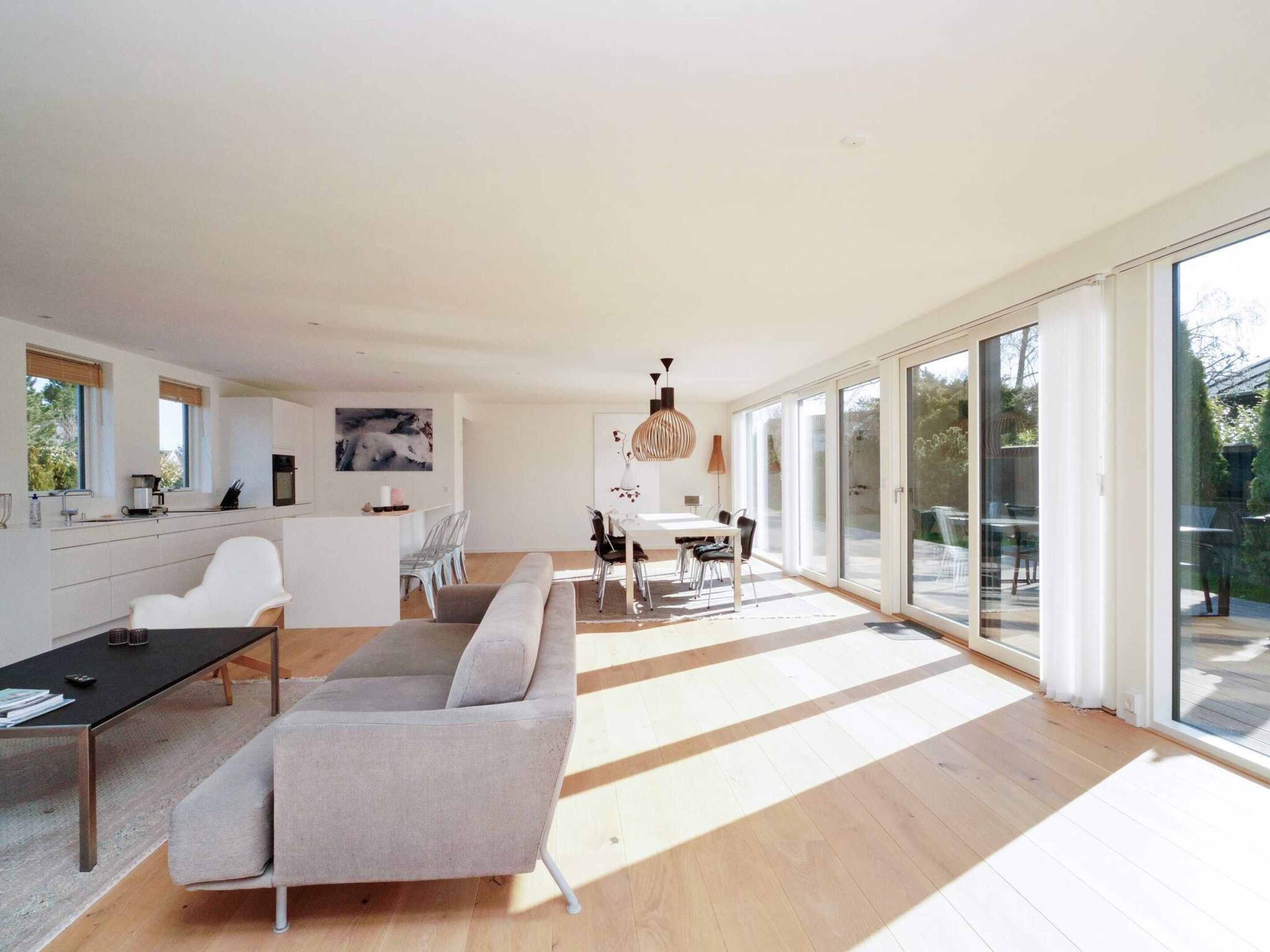 A modern interior with a kitchen, dining area, and a large sliding glass door leading to an outdoor space.